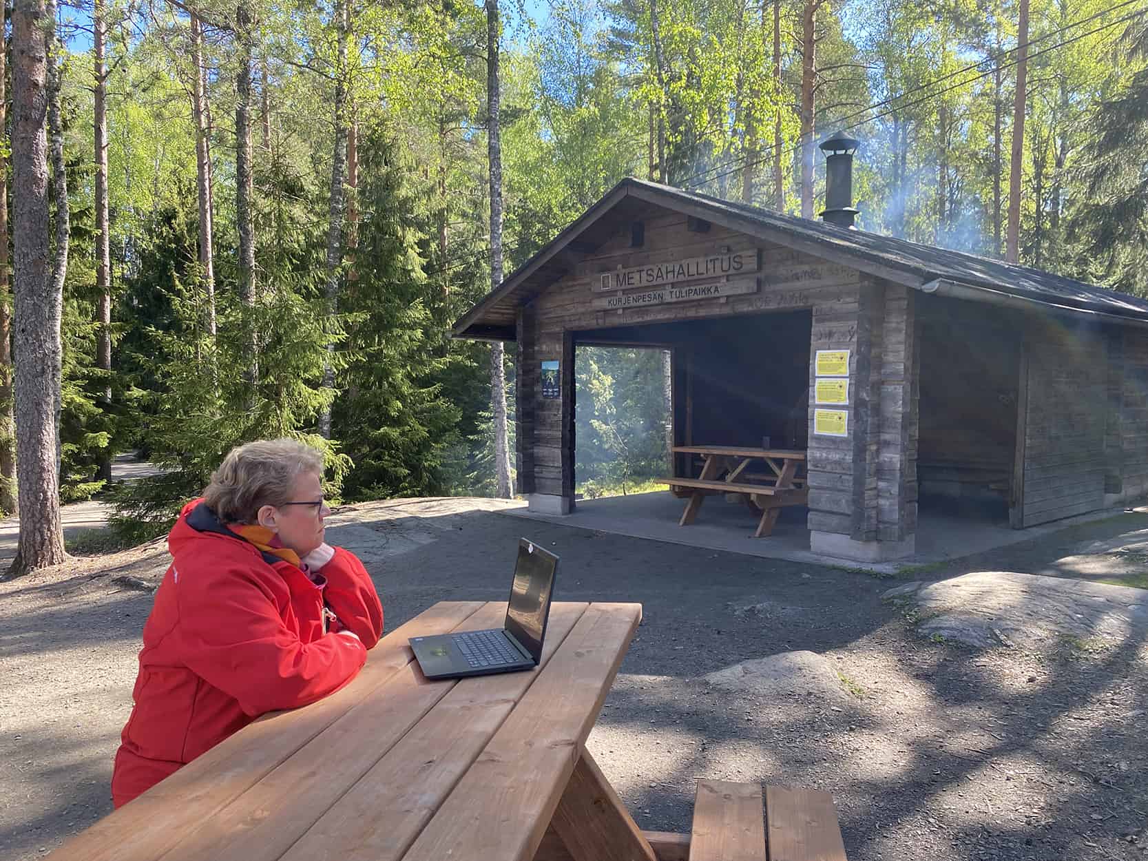 Taina Simola Kurjenrahkan kansallispuistossa. Takana näkyy nuotiopaikka.